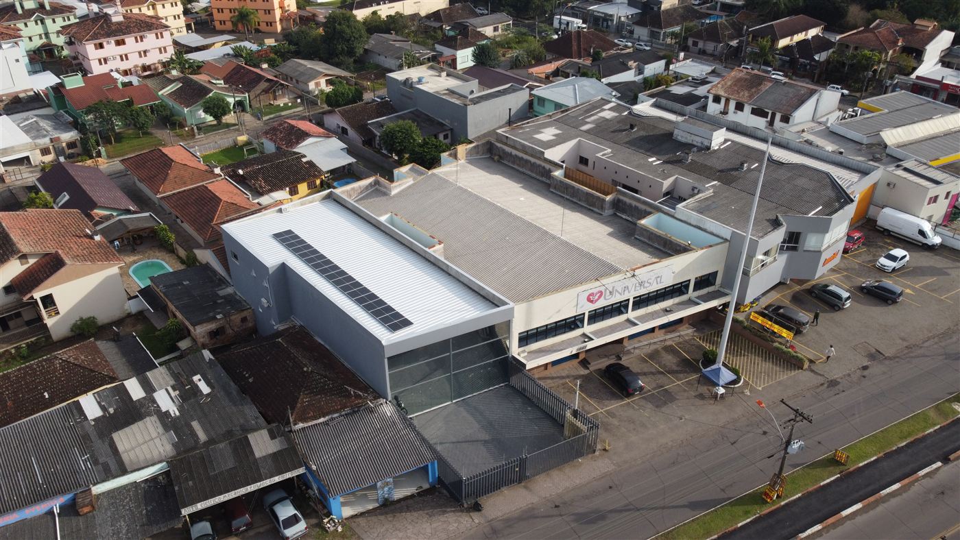 Vista aérea de prédio comercial moderno com fachada de vidro, na avenida